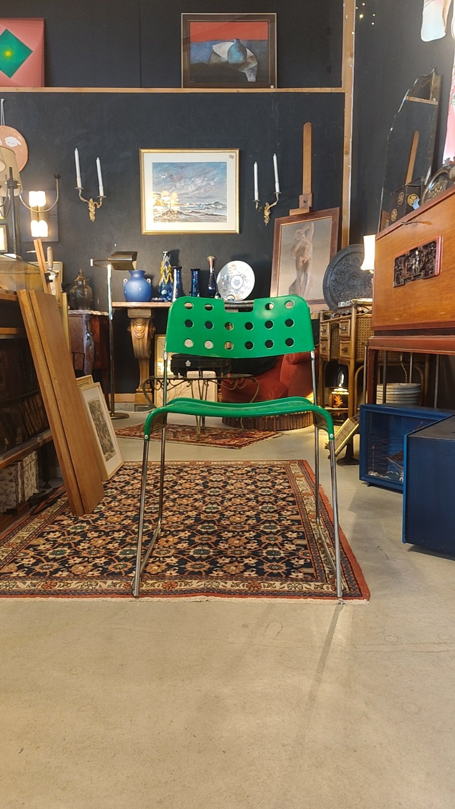 Photo originale de la chaise verte dans la boutique, avec la petite traverse métallique dans l’encoche du dossier.